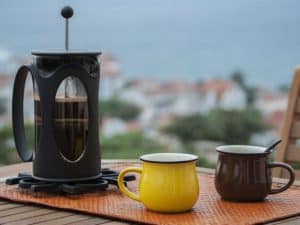 cafetera de émbolo y tazas de café