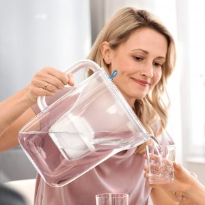 mujer con una jarra de agua filtrada 