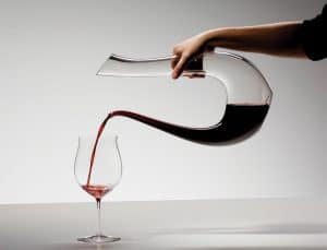 persona sirviendo vino con un decantador de vino