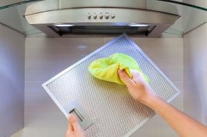 persona limpiando una campana extractora 