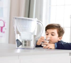 niño con una jarra de agua filtrada 