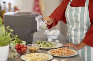 mujer haciendo pasta con una máquina para hacer pasta 