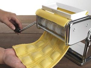 persona haciendo pasta con una máquina para hacer pasta 