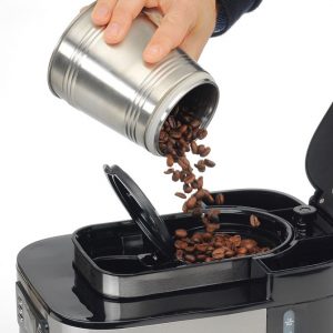 poner granos de café en una cafetera con molinillo